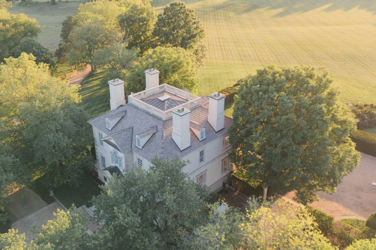 Sweeping rolling lawns, mature trees, and private estate driveway at golden hour